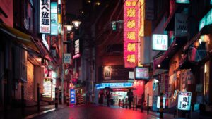 Nocna ulica w Japonii z neonowymi szyldami i oświetlonymi sklepami.